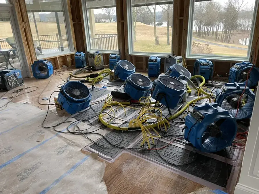 Rows of air movers and floor drying mats drying a sunroom after water damage