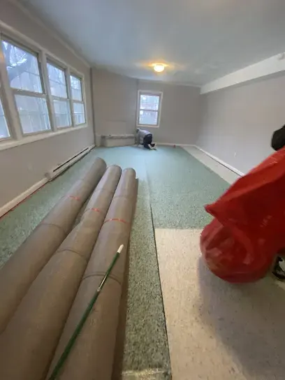 Wet carpet rolled up for extraction in a flooded room