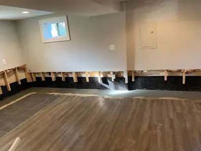 Finished basement with flooring pulled and wall bottoms opened after basement flooding