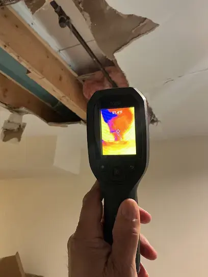 Thermal imaging camera checking a water damaged ceiling opening for a ceiling leak