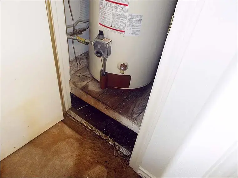 Water heater closet with a water damaged floor after a tank leak